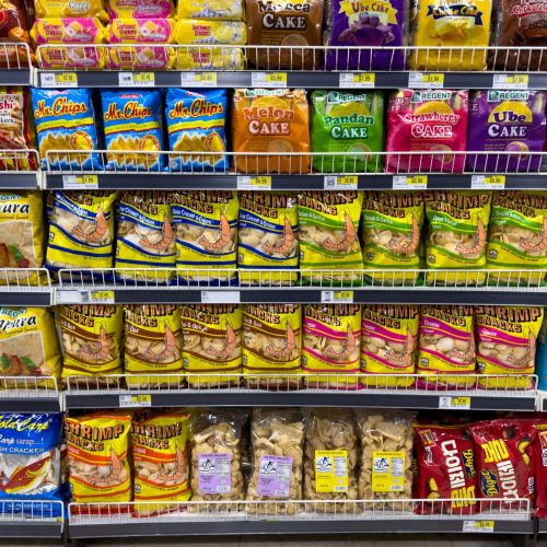 Colorful snack packages neatly displayed in a supermarket aisle showcasing Asian food variety.