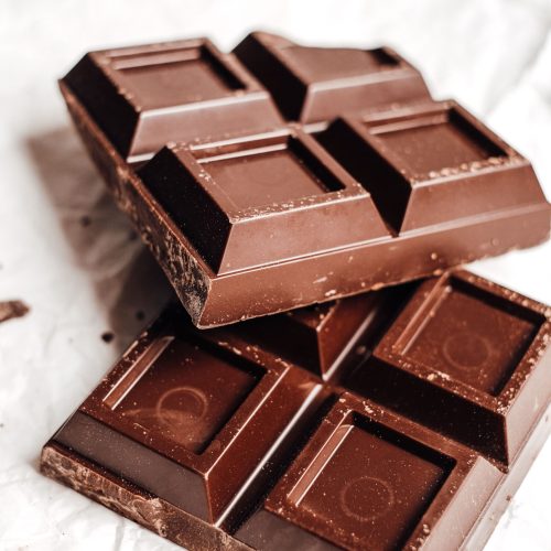 Close-up of tasty chocolate bars stacked on a white background.